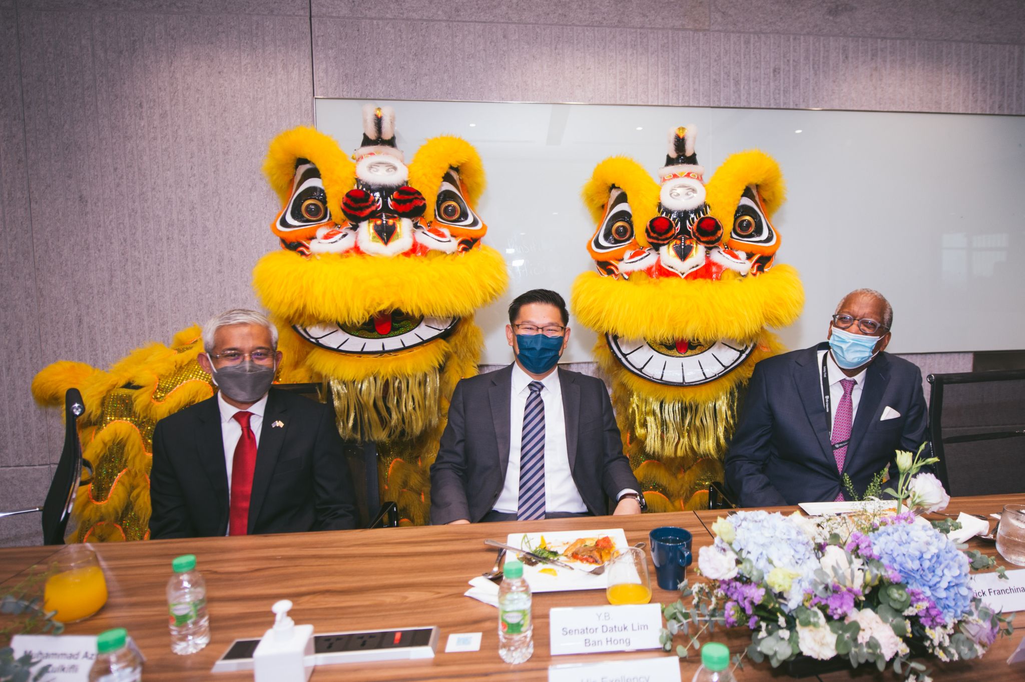 Business leaders participating in a Global Business Services (GBS) location strategy meeting with international partners during a cultural welcome ceremony.