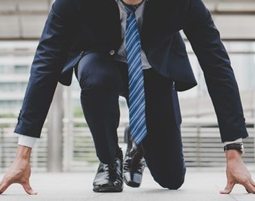 Business professional in a starting position, representing readiness, ambition, and achieving business goals.