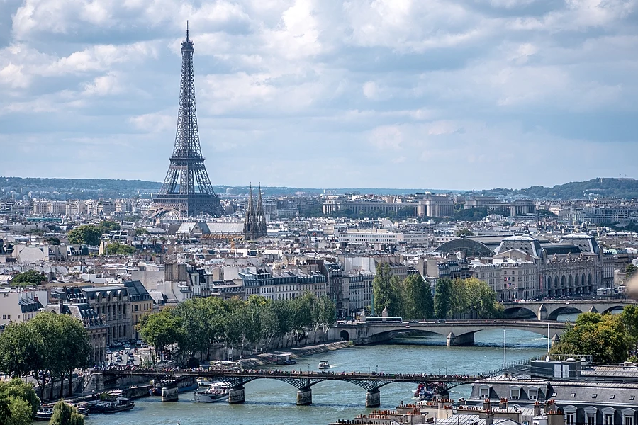 Panoramic view of the Eiffel Tower overlooking the Paris city skyline and the Seine River in France.