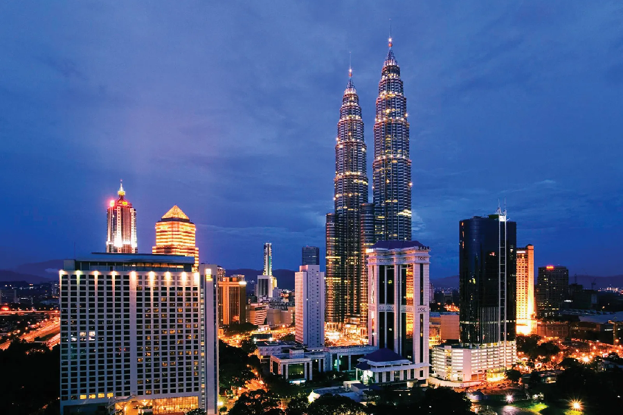 Night view of the Petronas Twin Towers and Kuala Lumpur city skyline in Malaysia.