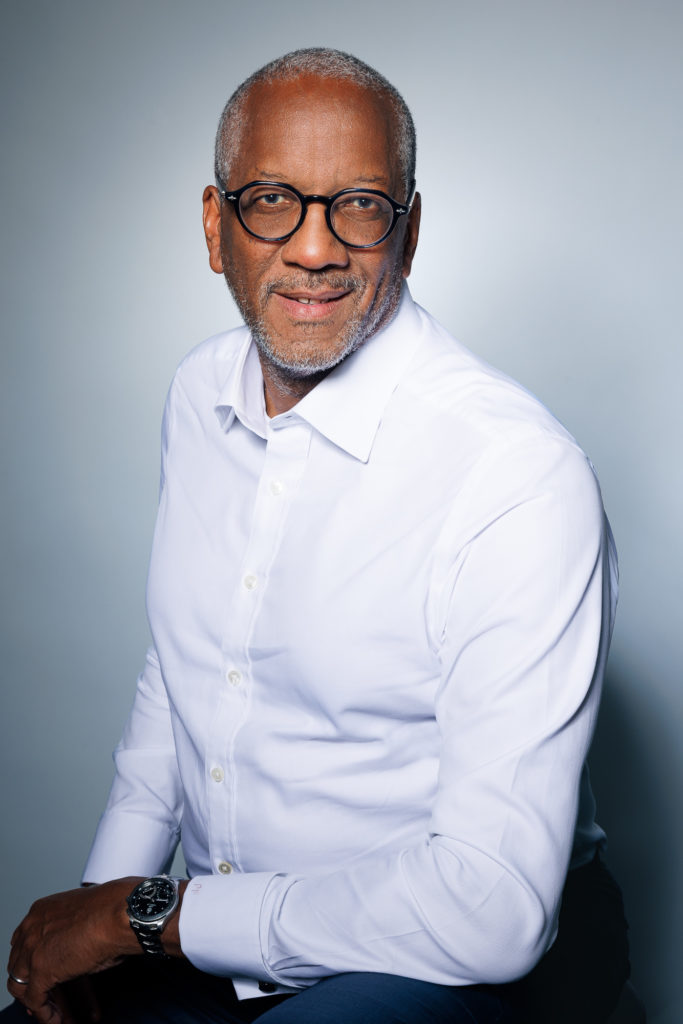 Professional portrait of a senior business consultant smiling in a white shirt, representing EarthTone Advisors' leadership and expertise.